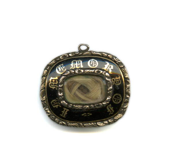Metal pendant with letters around a small glass window that shows a small lock of blonde hair inside the pendant.